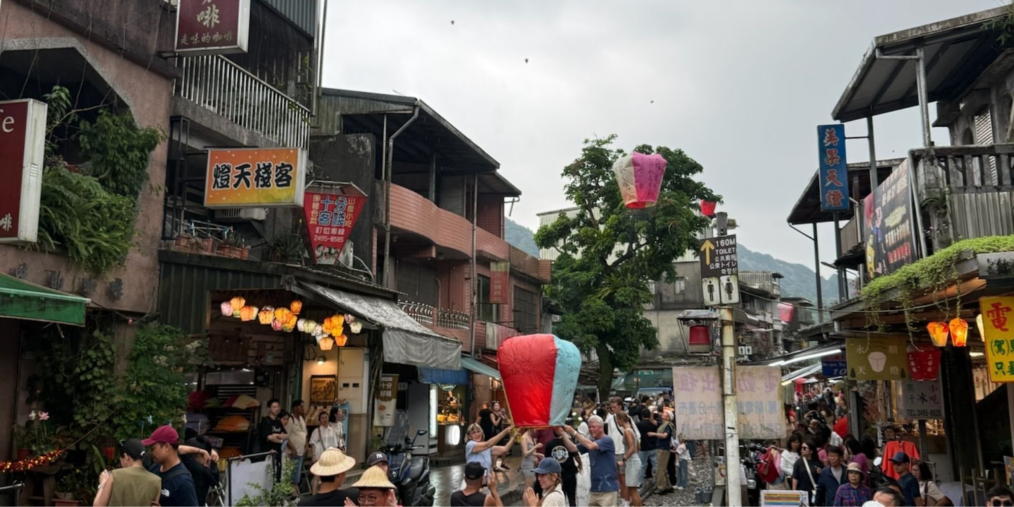 Toeristen laten een wenslantaarn op langs de treinrails van Shifen Old Street in Taiwan.