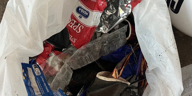 Inhoud van een afvalzak met gevonden zwerfafval tijdens de prikactie, waaronder verpakkingen, blikjes en ander single-use plastic