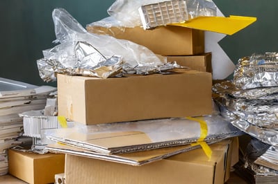 Firefly-messy-stacks-of-used-packaging-material--a-pile-of-cardboard-and-a-pile-of-transparant-foil--(2)